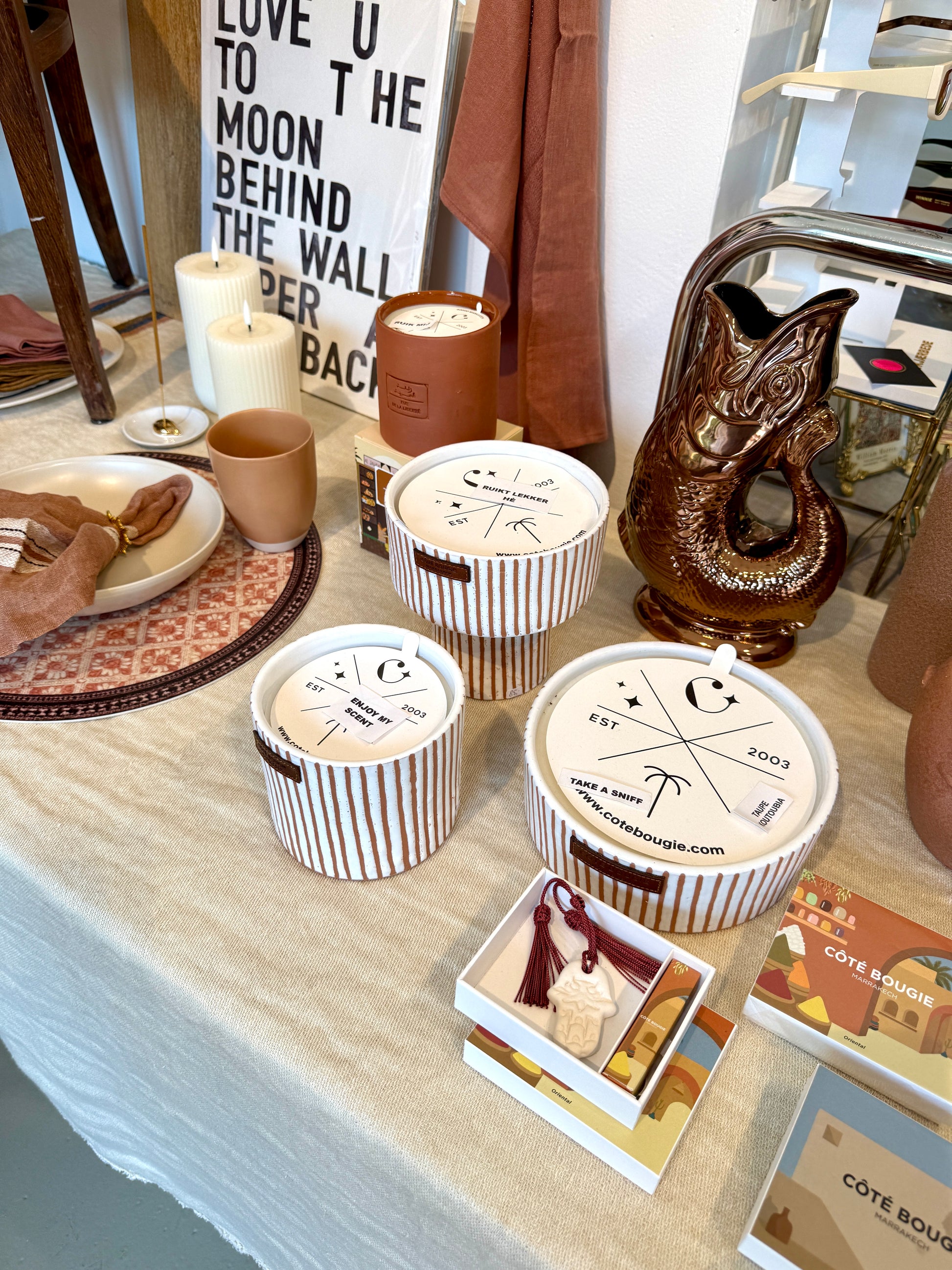Coté Bougie Marrakech, te koop bij Wanted by Das in Eindhoven. Deze heerlijk geurende kaars in een met de in Marrakech, hand gemaakte terra cotta pot, is een prachtig item om je interieur net dat vleugje extra te geven. Prachtig als cadeau, voor jezelf of een ander. Ze zijn er in verschillende maten, kleuren en geuren. Combinatie van de geuren Komijn – Wierook – Amber 12 x 10 cm 80 brand uren